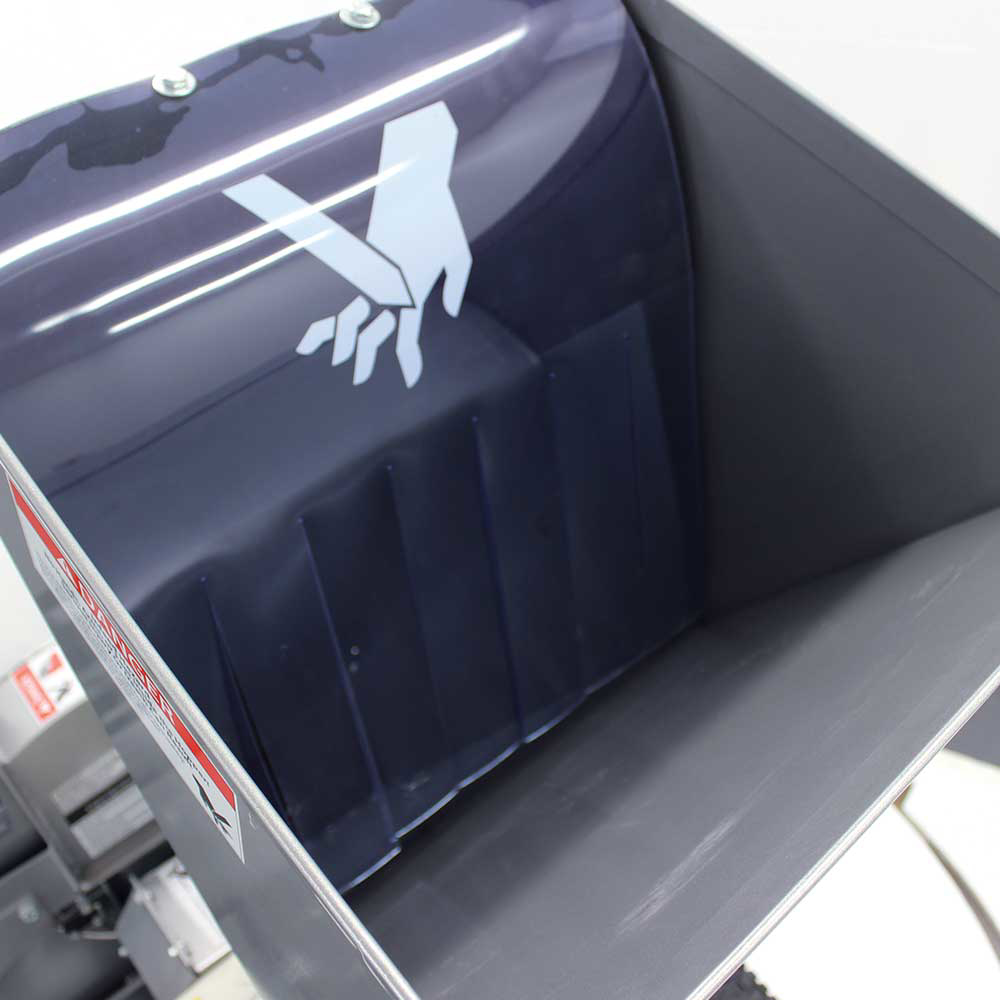 A view from inside the hopper of the Dosko 13-21T-13H brush chipper, showing the safety symbols on the interior walls.