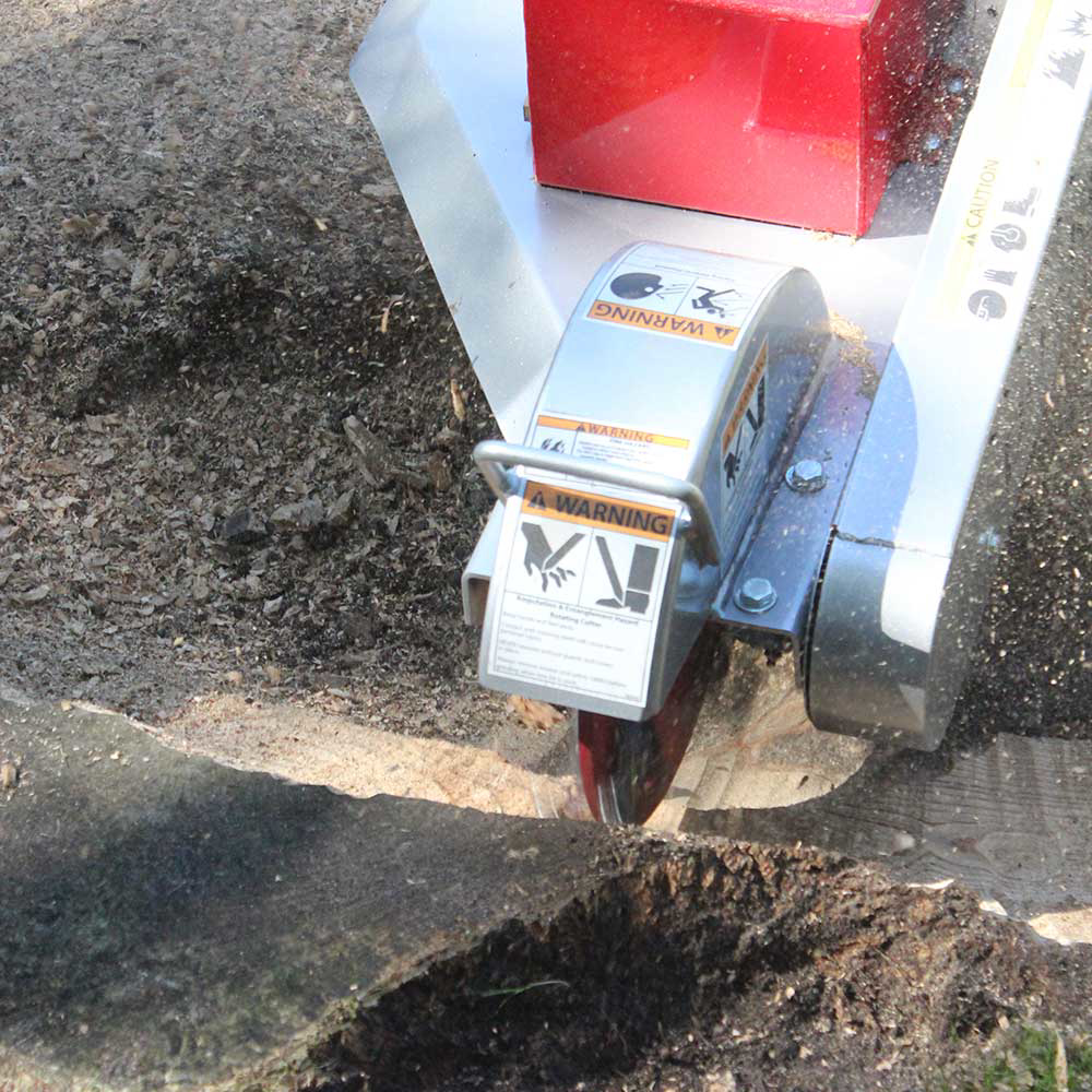 A close-up view of the Dosko 691SP-20HE's cutting wheel, which features multiple sharp teeth, in the process of grinding a stump.