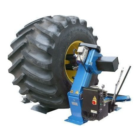 A front view of the blue Atlas TTC303 Super Duty Truck Tire Changer with a large tire on the table and a wired mobile control unit.