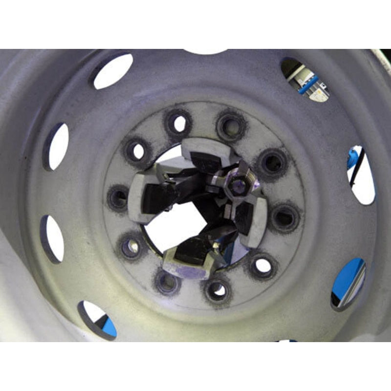 A view of the Atlas TTC303 Truck Tire Changer's jaws holding the center of a rim, showcasing the clamping mechanism.