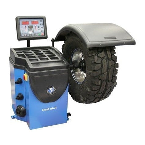 A blue Atlas WB41 wheel balancer with a truck tire mounted, showing the tire's size as 38.5x14.5-16.5LT and a weight of 105 lbs.
