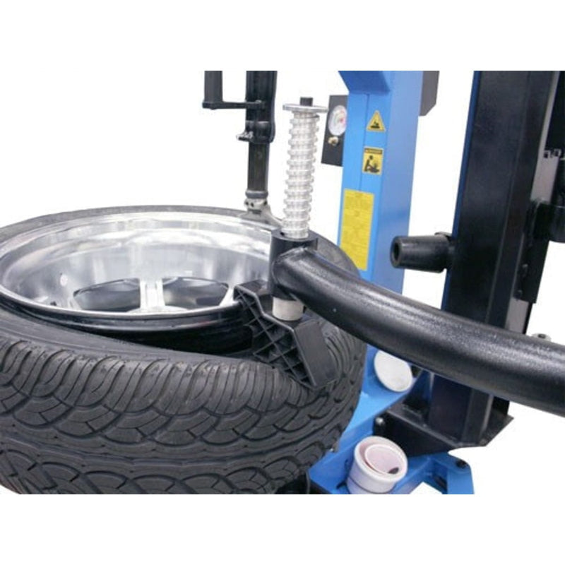 The Atlas TC755EZ tire changer with a tire mounted on the turntable, with the bead roller on the assist arm positioned against the tire.