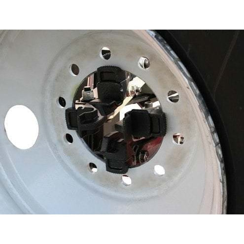 The four-jaw chuck of the Atlas TTC301 securely holding the center of a large truck wheel with its clamps.