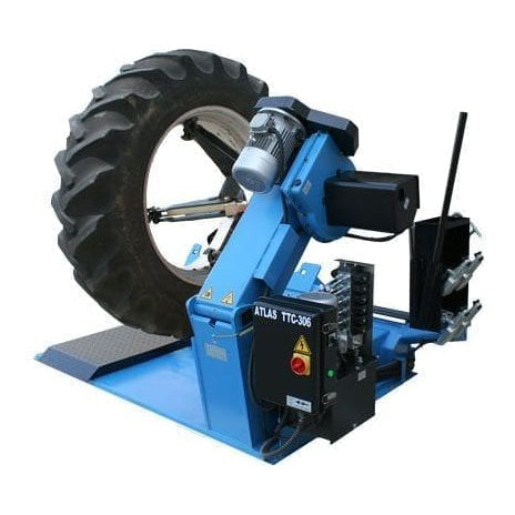 A large, heavy-duty blue and black tire machine, the Atlas TTC606 commercial truck tire changer, with a tire mounted on its hydraulic arms, positioned on a blue metal base.