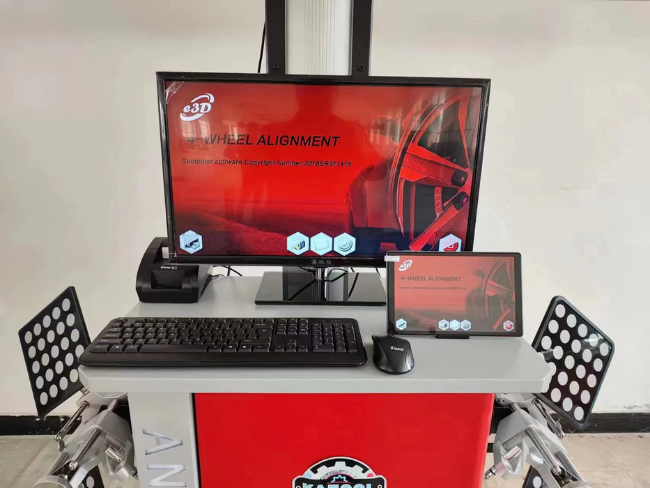 A product shot of the Katool KT-AV6 3D Wheel Aligner and its included accessories on a red mobile cart. The image features a large computer screen displaying a "WHEEL ALIGNMENT" graphic, a keyboard, a mouse, a tablet, and the wheel targets, showcasing a complete alignment setup.