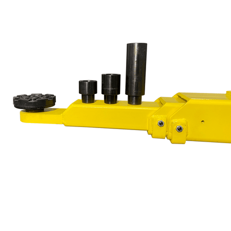 A close-up view of the adjustable lifting pads on the yellow arms of the Triumph C-7000 Two-Post Car Lift. The pads are black with a diamond texture and come with 3-inch and 6-inch truck adapters.