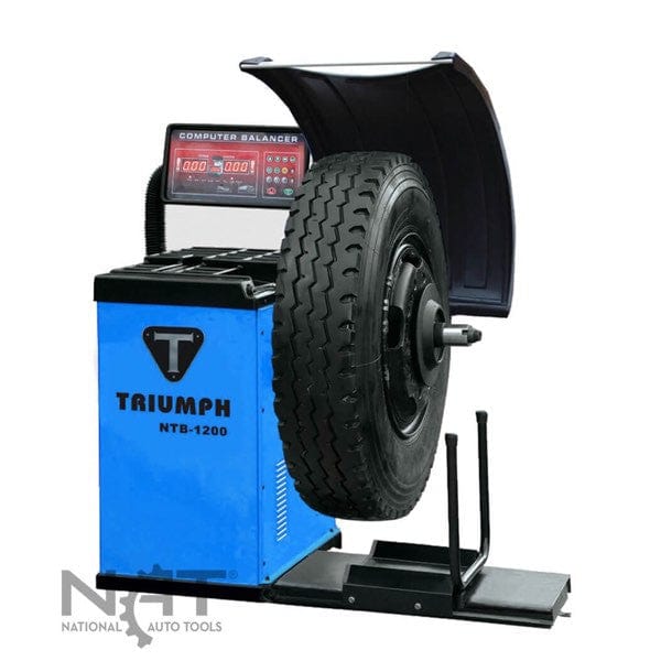 The Triumph NTB-1200 wheel balancer with a truck tire mounted and ready for balancing, highlighting its size and blue color.
