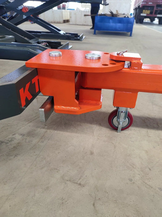 A close-up view of the caster wheel on the orange and black Katool KT-310 frame machine, showing its attachment point to the frame.