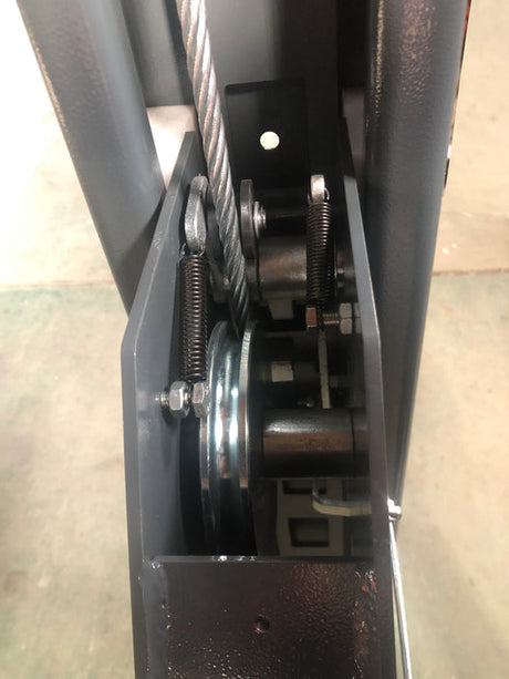 A close-up view of the interior workings of the Katool Four Post Vehicle Lift 11,000lbs KT-4H110, showing the cable, pulley system, and safety lock mechanism. The metal components are visible inside the lift's column