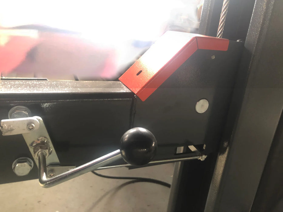 A close-up of the manual lock release lever on the Katool KT-4H110 4-post vehicle lift, with a red arrow graphic pointing to its function to lower the lift