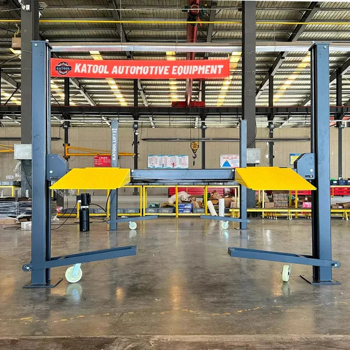 The black and yellow Katool 4-post car lift set up inside a large warehouse