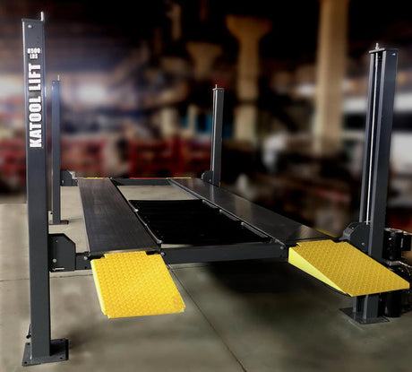 The Katool 4-post car lift with yellow approach ramps in a garage or workshop setting