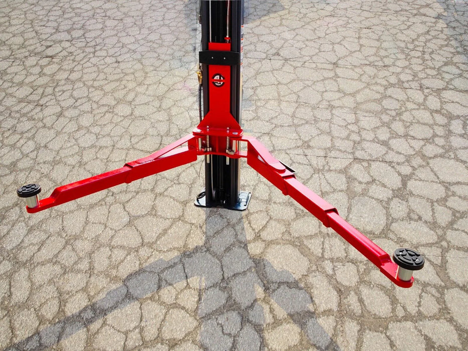 A detailed, low-angle close-up of the red lifting arms of the Katool KT-AS110D 2-post car lift, with the arms fully extended from the black post