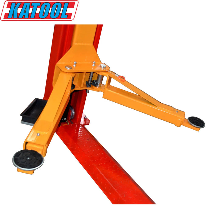 A detailed view of one of the Katool KT-H100 Vehicle Lift's lifting arms. The yellow arm extends from the red post and features a black, circular rubber pad at the end, designed to support the vehicle's frame