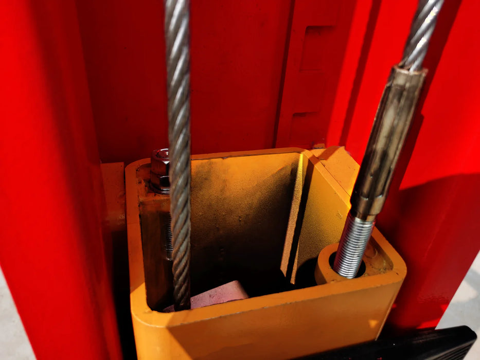 A detailed shot of the hydraulic components within the red lift column, showing the sturdy steel cables and the mounting hardware of the Katool KT-M110 lift.