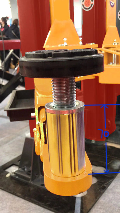 A close-up of the adjustable, yellow extended support adapter on the Katool KT-M110 2-post lift, showing the heavy-duty screw mechanism and a black rubber pad.