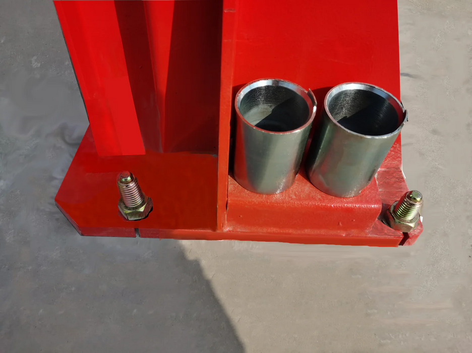 A close-up of the red base plate of the Katool KT-M110 lift, showing the anchor bolts and the two silver cylindrical rubber pads used for protection.