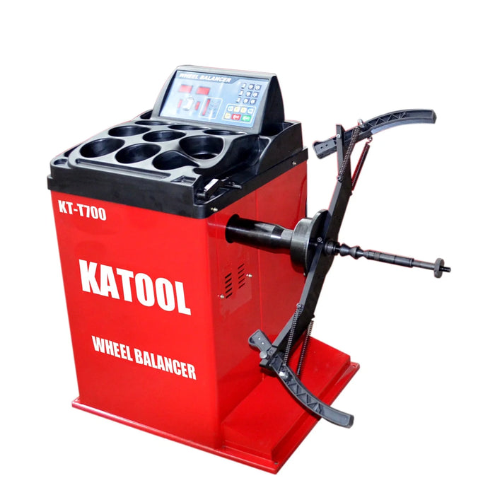 A red Katool KT-700 Wheel Balancer with the Motorcycle Wheel Balancer Adapter attached to its shaft, featuring the control panel with a digital display and multiple storage compartments on top.