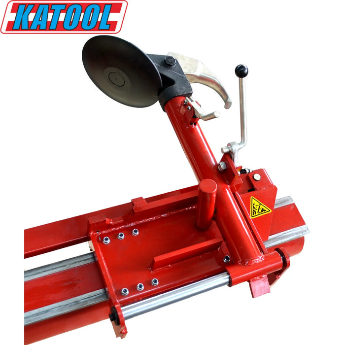 A detailed view of the Katool Four-Post Vehicle Lift Tire Changer Machine 11,000lbs KT-T160's bead breaker assembly. The angled shot shows the large, round bead breaker disc, the manual lever for operation, and the durable red metal frame that slides along the main body to efficiently break the tire bead.