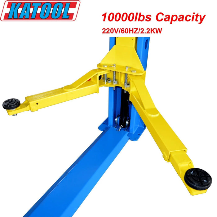 A close-up of the articulated yellow arms on the Katool H105 10,000 lbs. Two-Post Vehicle Lift. The image highlights the arm’s reach and screw-on pads, with a text overlay indicating the 10,000 lbs Capacity and 220V/60HZ/2.2KW power specifications.