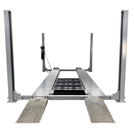 A front view of the gray Triumph NSS-11 11,000 lb four-post automotive lift with two aluminum ramps on the ground in front.