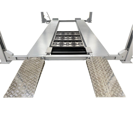 A front view of the gray runways of the Triumph NSS-11 four-post lift with the two diamond plate ramps.
