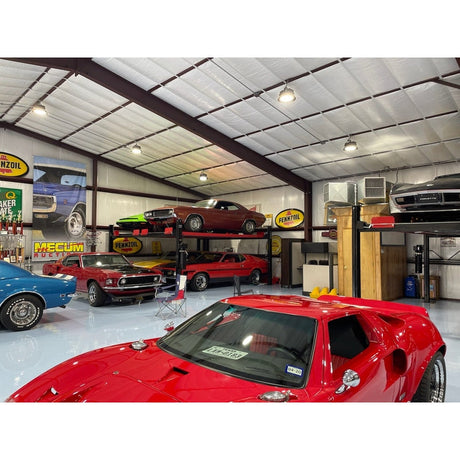 A close-up view of a metal safety latch on the black post of the Triumph NSS9000 4-Post Lift, showing a single-point lock release with a cable attached to a pulley.