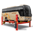 A large beige YUTONG bus is elevated on a red AMGO PRO-40E Heavy-Duty 4-Post Lift, highlighting the lift's substantial size and weight capacity for commercial vehicles.