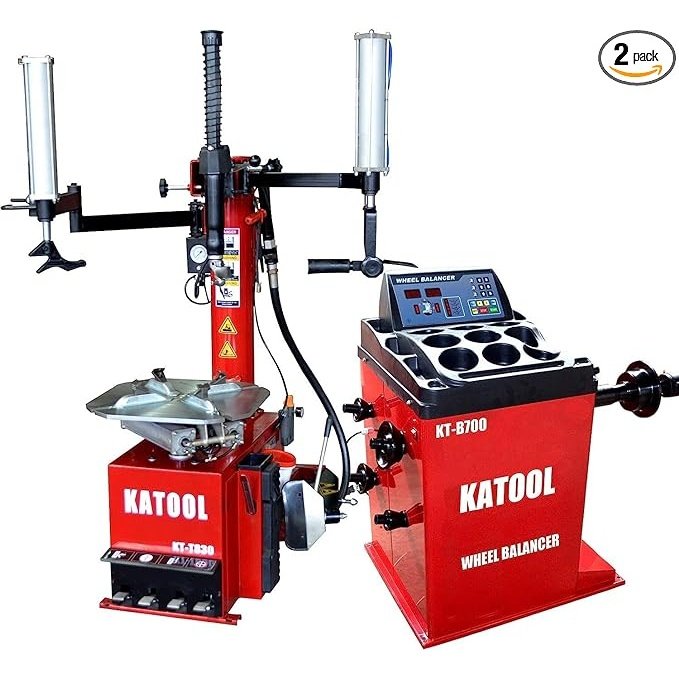 A product shot of the Katool T810 Tire Changer and B700 Wheel Balancer combo. The red and black machines are displayed side-by-side, with the tire changer featuring a protective hood and the wheel balancer ready for use. A circular icon with "2 pcs" indicates that this is a two-piece set.