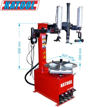 A full product view of the Katool T810 Tire Changer, highlighting its key dimensions. The image displays the red machine with its pneumatic assist arm and bead seator, featuring a detailed diagram with measurements for height (990 mm), width (507 mm), and depth (390 mm). The brand name "KATOOL" is prominently displayed on the side.