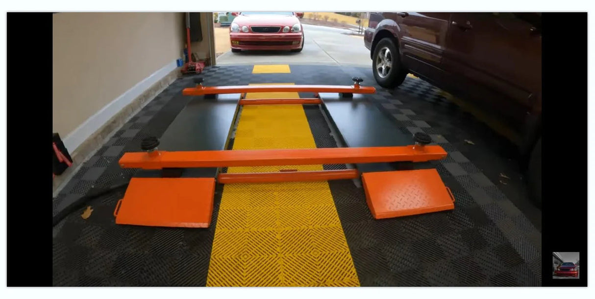 The portable X80-PNEUMATIC scissor lift shown on a gray and yellow floor within a garage setting
