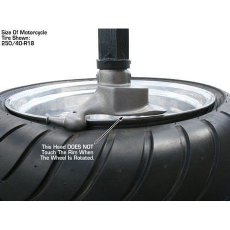 A close-up shot of the head of the Atlas TC289DAA tire changer, with text stating that the tire changer's head does not touch the motorcycle rim when the wheel is rotated.