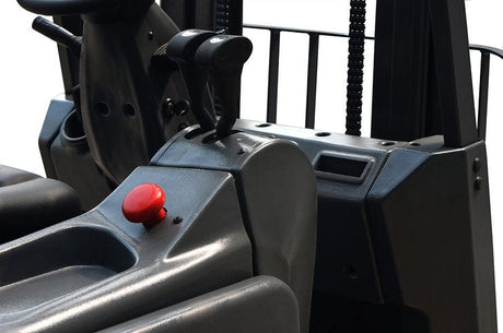 A close-up of the ergonomic controls and red emergency stop button inside the EKKO EK15A electric forklift's operator cabin.