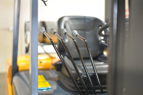 Close-up of the hydraulic control levers in the operator's compartment of the EKKO EK25-212LP Liquid Propane Forklift.