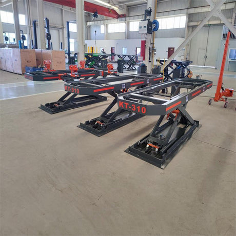 A wide shot of two Katool KT-310 frame machines set up side-by-side in a warehouse environment, with other equipment and machinery visible in the background.