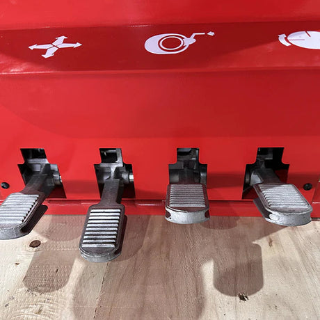 A close-up shot of the four foot pedals on the base of the Katool KT-T830 tire changer with a red background, showing the controls for operation.