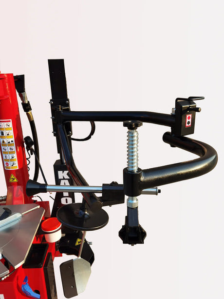 A close-up view of the black assist arm on the Katool KT-T835 tire changer, highlighting the heavy-duty spring mechanism and ergonomic handle for precise tire mounting.