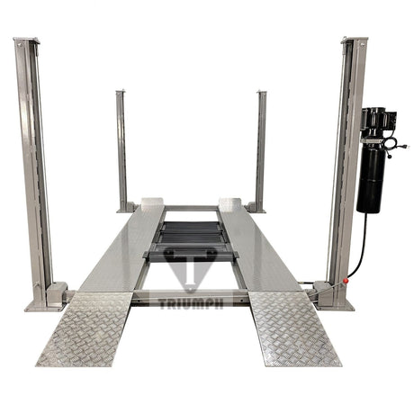 A front view of the Triumph NSS-8 8,000 lb Four-Post Automotive Lift in a light grey finish with a power unit attached to the front right post. The lift has diamond plate runways and approach ramps.