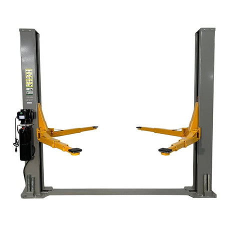  A front view of the Triumph NT-9 Two-Post Auto Lift in a grey color, with its lift arms in the medium height position. The power unit is visible on the right post, and a black hose runs between the two posts along the floor.