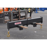 A black Haugen telehandler rigid spreader bar with two swivel hooks attached, designed for heavy-duty lifting and material handling.